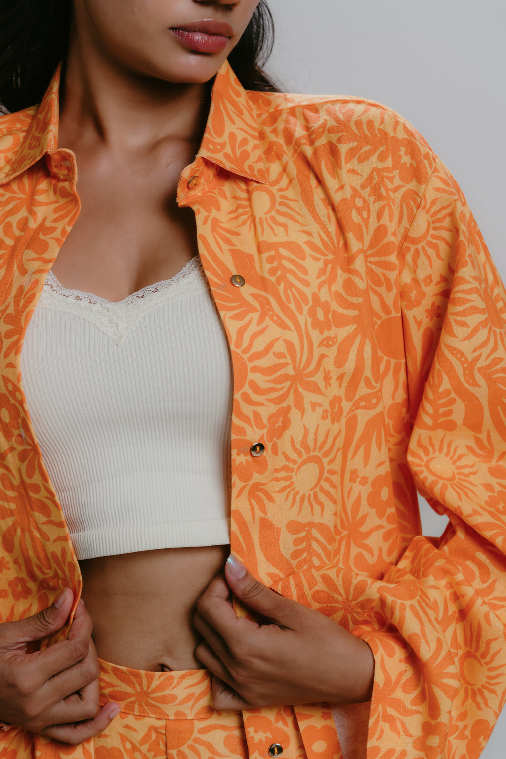 Orange printed shirt open over white tank top