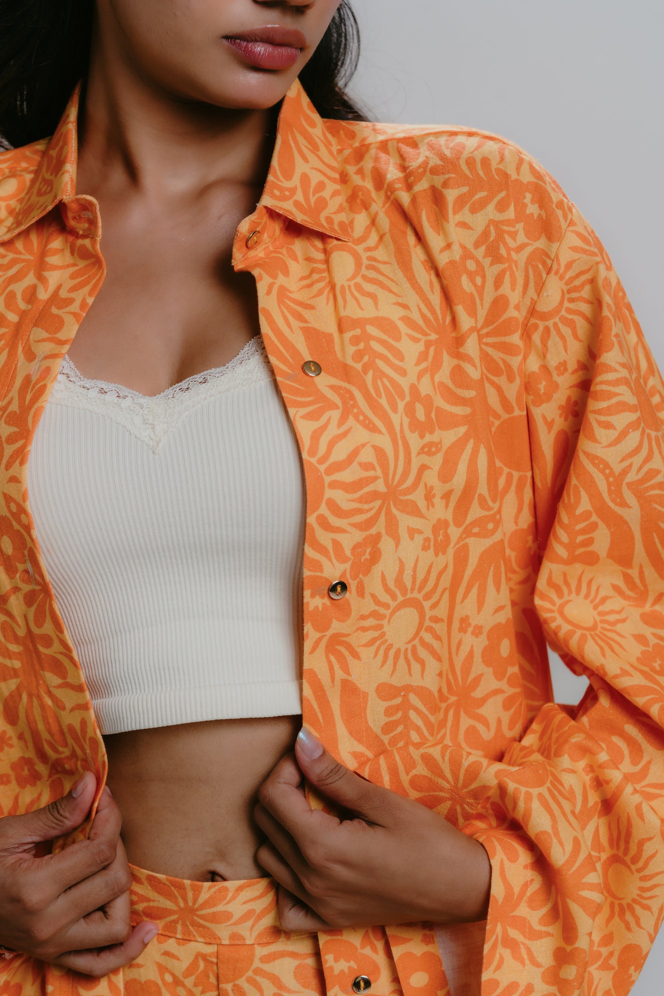 Orange printed shirt open over white tank top